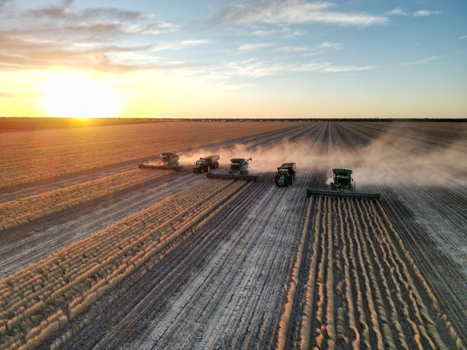 Aerial view of headers running through the sunset