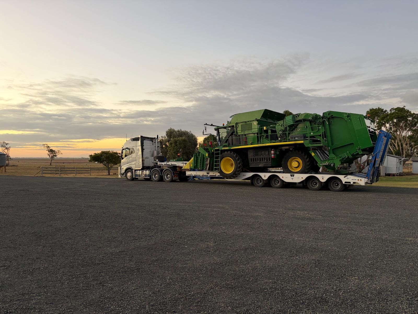 John Deere CP690 cotton picker loaded on a float ready for transport
