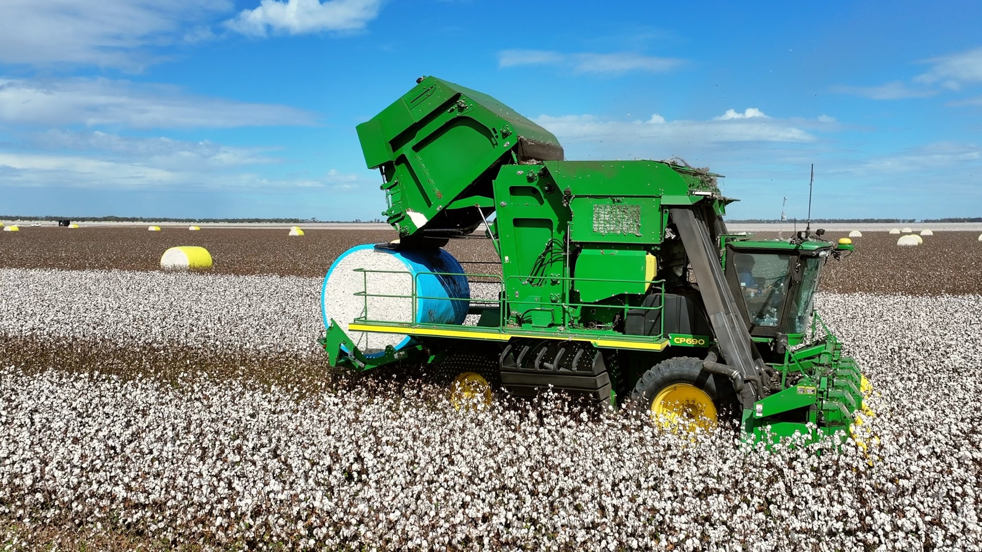 John Deere CP690 round-module cotton picker dropping a bale